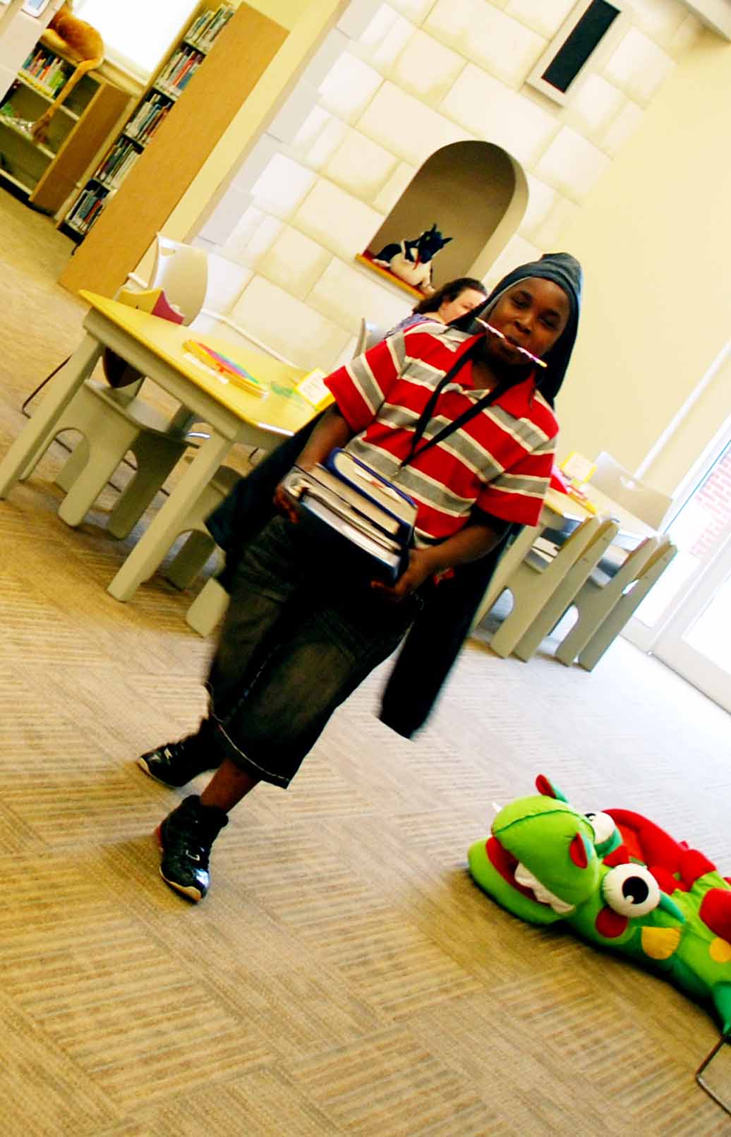 Jamar Flowers, 13, carries a load of books to his study area.