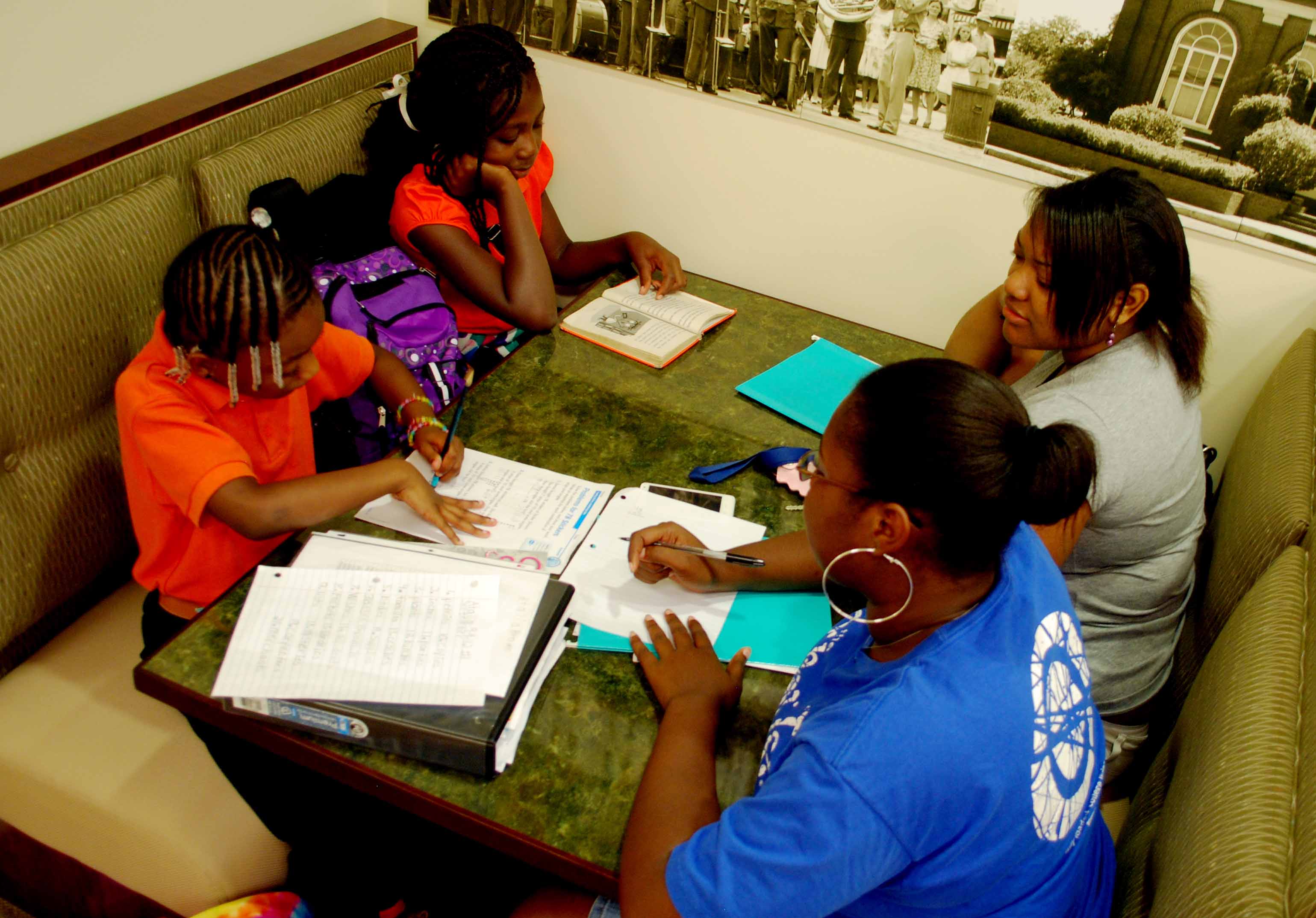 Natalia Brown, 8, and Taurianna Clark, 10, study with Troy University student volunteers, Brittney Strong and Tamara Andrews.