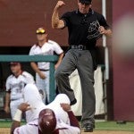 Umpire Rickey Scarbery calls Troy's Trae Santos (19) out after a play at home during an NCAA college baseball game against Florida State in Tallahassee, Fla., Saturday, June 1, 2013. (Photo/Thomas Graning)