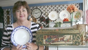 Salvation Army Director Kim May shows off a plate that can be purchased for a deal at the Salvation Army Thrift Store. The same plate is a pricey, collectible item on eBay. Below, May dresses a mannequin in a fashion found at the store.