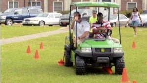 Messenger PHoto/Quinta Goines Jemarius Yeldell of Montgomery practiced on a 50-cone obstacle course with Trooper Kevin Cook. Yeldell had to focus on not hitting any of the cones while wearing glasses that impaired his vision. The simulation taught students the effects of distracted driving.