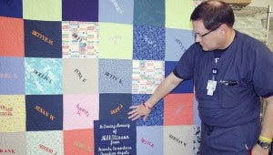 Jeff Johnson, Troy Regional Medical Center pharmacist, is one of the many friends of the late Nell Stinson who have squares on a remembrance quilt that is on display in the hospital pharmacy. The quilt is made from scraps of the scrubs of many of Stinson’s friends at TRMC.