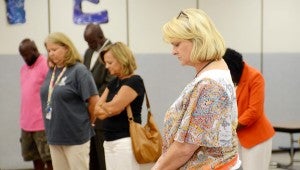 MESSENGER PHOTO/COURTNEY PATTERSON Troy Elementary School Principal Teresa Sims joins teachers, staff, parents and students in prayer Tuesday. Several gathered to pray over the upcoming school year.