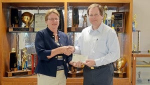 MESSENGER PHOTO/COURTNEY PATTERSON Becky Baggett, PLAS headmaster, left, accepts a $1,000 check from Troy Bank & Trust presented by Jeff Kervin, TB&T president and CEO.