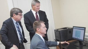 MESSENGER PHOTO/JAINE TREADWELL Probate Judge Wes Allen has set up computer workstations in Brundidge and Goshen to make driver’s license and vehicle tag renewals more convenient. Allen, seated, was in Brundidge Tuesday to demonstrate how the renewal program works. Standing, Brundidge Mayor Jimmy Ramage, left, and Goshen Mayor Jack Waller thanked Allen for making this service available in their areas of the county.