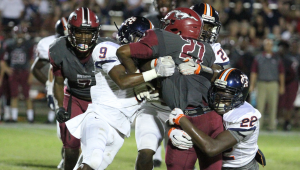 Photo/dan smith Chance Pollard (9), Paul Galie (22) and Jamal Smith (27) stuff Stanhope Elmore running back Karrem Jackson. inset: Quaterback D.Q. Toney finished the night 11-16 for 190 yards and a touchdown in Charles Henderson’s 21-14 win over the Mustangs on Friday night. 